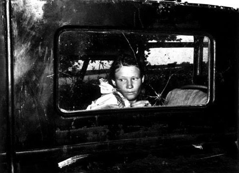 Migrant worker looking through back window of automobile near Prague, Oklahoma.  Lincoln County, Oklahoma, 1939  Silver gelatin print  Russell Lee